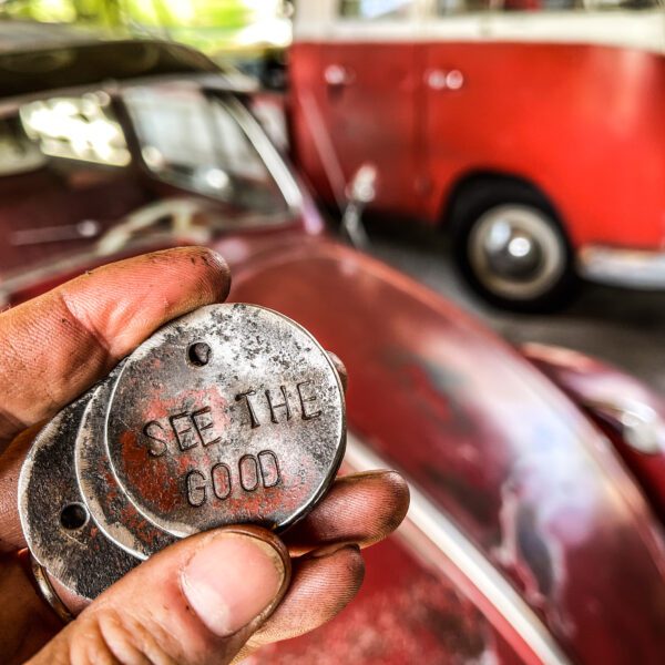 A person holding up a metal key to a Pickle Chips - Support Our VW Bus Project.