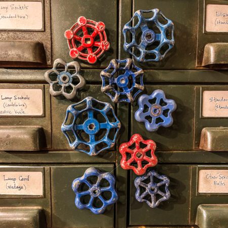 A set of Shut-Off Valve Knob Magnets (set of 3) on a green cabinet.
