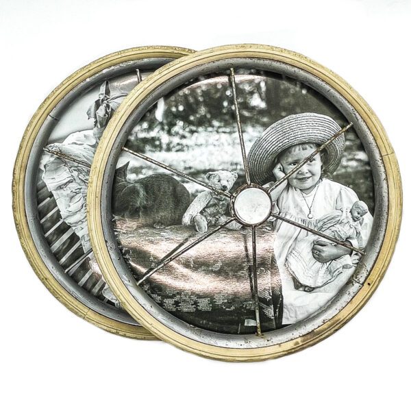 A photo of a child on a vintage baby buggy wheel picture frame.