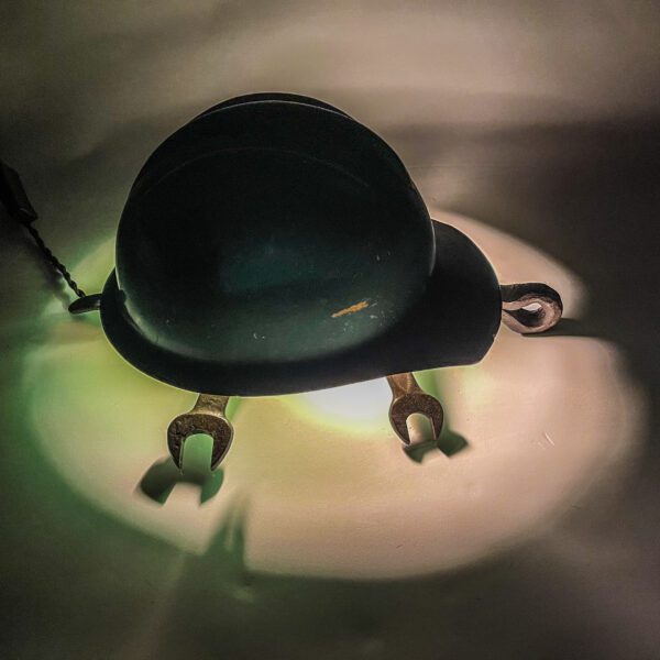 A Turtle Lamp with a hard hat on it.