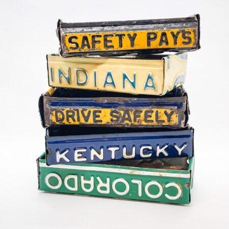 A stack of Vintage License Plate Valet Trays on a white background.