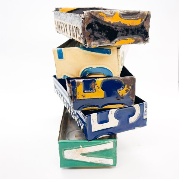 A stack of Vintage License Plate Valet Trays stacked on top of each other.