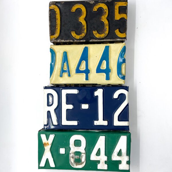 Three Vintage License Plate Valet Trays stacked on top of each other.