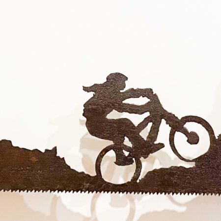 A metal sculpture of a Mountain Biker Freehand Plasma cut saw riding a bike.